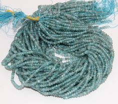 the beads have been wrapped in blue and green string with tassels on them