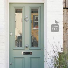 a green front door with the number 757 on it's side and an image of a brick building in the background