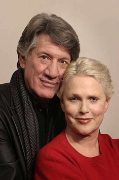 an older man and woman pose for a photo with their arms around each other's shoulders