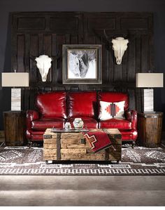 a living room with red leather furniture and cow heads on the wall