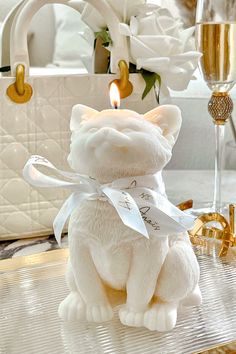 a white teddy bear sitting on top of a table next to a glass of wine