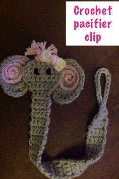 crochet pacifier clip with flowers on it and the tag in front says, crochet pacifier clip