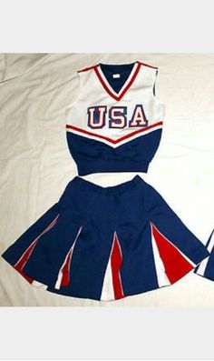 two cheerleader uniforms are laying on a bed