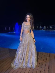 This lehenga set is hand embroidered with all-over sequin, crystal, and cutdana work on a nude gold net base. Paired with a crystal-embellished cold shoulder blouse with tassel detailing and an attached drape.DELIVERY TIMEPlease allow 8-12 weeks for your outfit to arrive.FABRIC DETAILSNetProfessional cleaning only. Glamorous Choli With Mirror Work For Reception, Glamorous Semi-stitched Hand Embellished Choli, Glamorous Hand Embellished Choli For Reception, Glamorous Floor-length Choli With Mirror Work, Traditional Embellished Skirt Set For Wedding, Glamorous Embellished Anarkali Set With Traditional Drape, Glamorous Lehenga With Mirror Work And Traditional Drape, Glamorous Gown With Zari Work For Reception, Glamorous Embellished Choli For Diwali