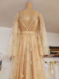 a mannequin wearing a dress with gold stars and sequins on it