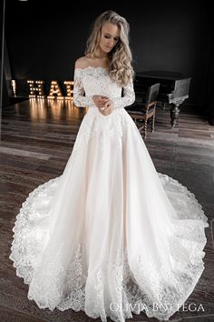 a woman in a white wedding dress standing on a wooden floor