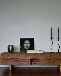 a wooden table with two candles and a photograph on it next to a candle holder