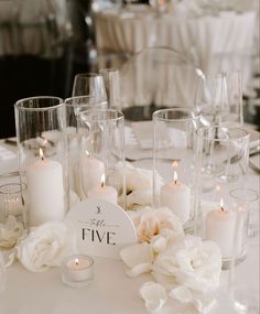 the table is set with candles, flowers and napkins for an elegant wedding reception