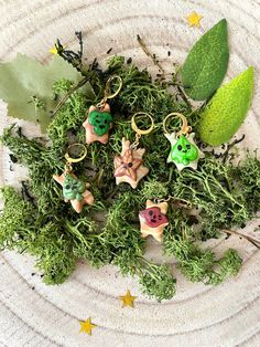 some green plants are on a plate with little keychains in the middle and stars around them