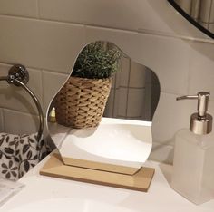 a bathroom sink with a mirror and soap dispenser on top of it