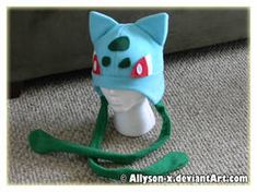 a blue and green cat hat on top of a white headband with red eyes