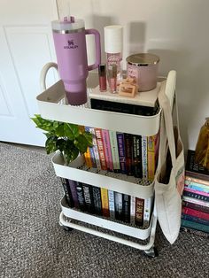 a stack of books sitting on top of a white cart