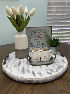 there is a tray with two coffee mugs and flowers in the vase on it