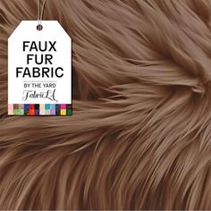 a tag that says faux fur fabric by the yard is shown on top of a furry animal