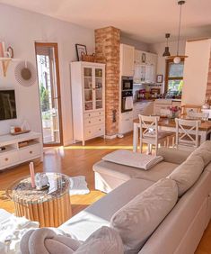 a living room filled with furniture and a flat screen tv on top of a wooden floor