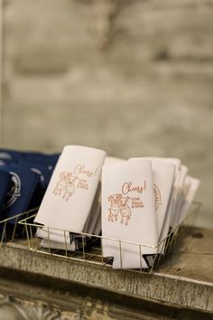 napkins are sitting in a wire basket on the counter top next to each other