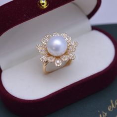 This ring features a stunning 11-12mm freshwater pearl and a floral-shaped cubic zirconia for a touch of elegance. Made with 4A quality pearls, in an open closure design, this ring is crafted with gold vermeil and sterling silver. A timeless piece for any occasion. Product Information Pearl Type Freshwater Pearl Origin China Shape Round Quality AAAA Size 11-12mm Nacre Very Thick Color White,Purple Luster Very High Pearl Rings In Gold For Women, Elegant Pearl Ring With Cubic Zirconia, Elegant Cubic Zirconia Flower Ring For Formal Events, Elegant Cubic Zirconia Flower Ring, Elegant White Flower Ring, Elegant Open Flower Ring With Cubic Zirconia, Luxury Pearl Ring With Cubic Zirconia For Wedding, Luxury Cubic Zirconia Pearl Ring For Wedding, Elegant Pearl Ring With Diamond White Cubic Zirconia