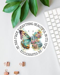 a sticker that says everything is beautiful and has butterflies on it next to a keyboard