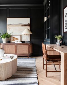 a living room with black walls and wooden furniture