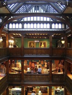 the inside of a building with people looking at items on display in glass cases and windows