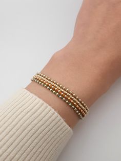 a woman's arm wearing a bracelet with beads