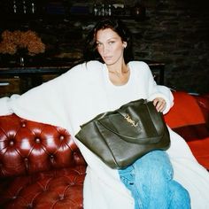 a woman sitting on a couch holding a purse