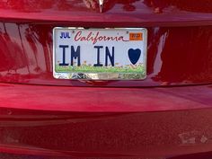 a license plate on the back of a red car that says i'm in