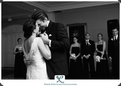 a bride and groom share their first dance at their wedding reception in front of the bridal party