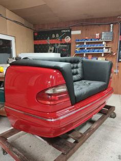 a red car is being worked on in a garage