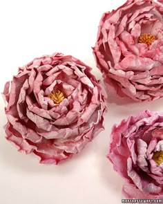 three pink paper flowers sitting next to each other