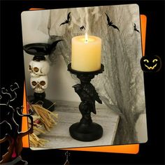 a candle that is sitting on a table next to some skulls and other halloween decorations