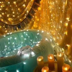 an inflatable hot tub surrounded by candles and curtains with lights on the walls