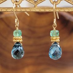 "Handcrafted in our studio, these stunning one-of-a-kind earrings sparkle with your every move. Hand wire wrapped and made with genuine gemstones. DETAILS * Gemstones: green emerald 4mm faceted rondelles & london blue topaz 6x8mm faceted teardrop briolettes * Length: 5/8\" drop * Metal: 14k gold filled wire & beads * Earwire: 14k gold filled hook IMPORTANT INFORMATION * Item size may appear larger or smaller than actual size on your screen * Actual colors may appear different in person than on y Gemstone Dangle Earrings, Light Green Emerald, Earrings 2024, Briolette Earrings, Wire Beads, Ocean Jewelry, Earrings Inspiration, Sparkle Earrings, Black Jewelry