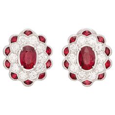 If you love red, you're sure going to love these! At the center of each earring is a rich red ruby weighing approximately 0.74ct each (1.48cttw) surrounded by a halo of fine white natural diamonds (1.01cttw) and an additional outer halo of rubies for another .54cttw. The vintage design perfectly showcased the red rubies showing off their phenomenal light return and even color saturation. The 14kt white gold oval ruby earrings measure approximately 15mm long x 12.6mm wide and weigh 3 grams. Dressed up or down, these ruby earrings are sure to become a new favorite in any collection! Ruby And Diamond Earrings, Art Deco Drop Earrings, White Gold Drop Earrings, White Gold Diamond Band, Vintage Style Art, Gold Diamond Band, Halo Earrings, Ruby Engagement Ring, Art Deco Engagement