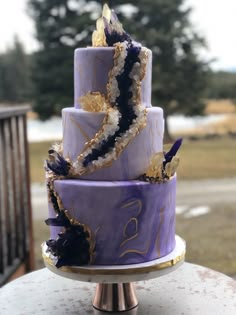 a purple and gold cake sitting on top of a table