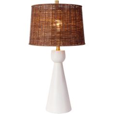 a white table lamp with a wicker shade on the base and a gold colored light bulb