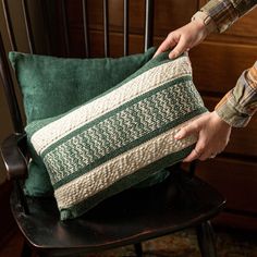 a person holding a pillow on top of a chair