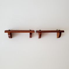 two wooden shelfs are mounted on the wall