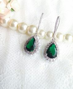 Long and shiny classical earrings made with cubic zircon micro inlay,  emerald green crystal and faux pearls around the rim.  They are One Of A Kind Perfect for a bride, bridesmaid or any special occasion to add some diamond glamour.The pictures are taken without any additional lights - only sunshine. Size: 1.7x4cm - 0.5x1.6" If you need more of them or have any special requests, please feel free to contact me :)Please visit my shop for more earrings https://www.etsy.com/uk/shop/MeAndEmily?ref=h Elegant Green Crystal Dangle Earrings, Green Cubic Zirconia Dangle Crystal Earrings, Green Teardrop Cubic Zirconia Earrings, Green Cubic Zirconia Chandelier Earrings For Formal Occasions, Elegant Green Cubic Zirconia Crystal Earrings, Green Teardrop Crystal Earrings, Green Crystal Teardrop Earrings, Elegant Emerald Crystal Drop Earrings, Elegant Emerald Drop Crystal Earrings