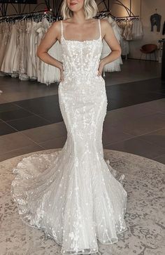 a woman in a wedding dress standing on a round rug with her hands on her hips