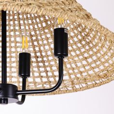 a chandelier made out of wicker and black plastic tubes with two lights on each end