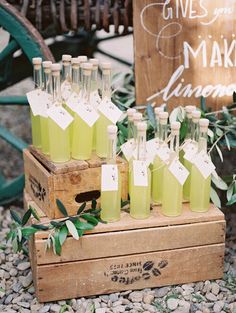 there are many bottles of green liquid on the wooden box and some leaves around it