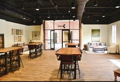 an empty restaurant with wooden tables and chairs