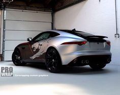 a silver sports car parked in front of a garage