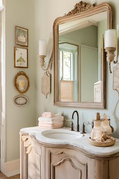 a bathroom with a sink, mirror and pictures on the wall