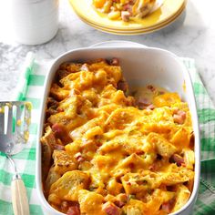 a casserole dish with ham and cheese in it on a green checkered table cloth