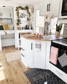 a kitchen with an oven, sink and stove top in the center is decorated with christmas wreaths