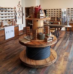 a store filled with lots of different types of items on wooden tables and chairs next to each other