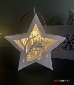 an ornament shaped like a star with a house on it