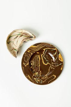 a brown and white plate sitting next to a banana on top of a white table